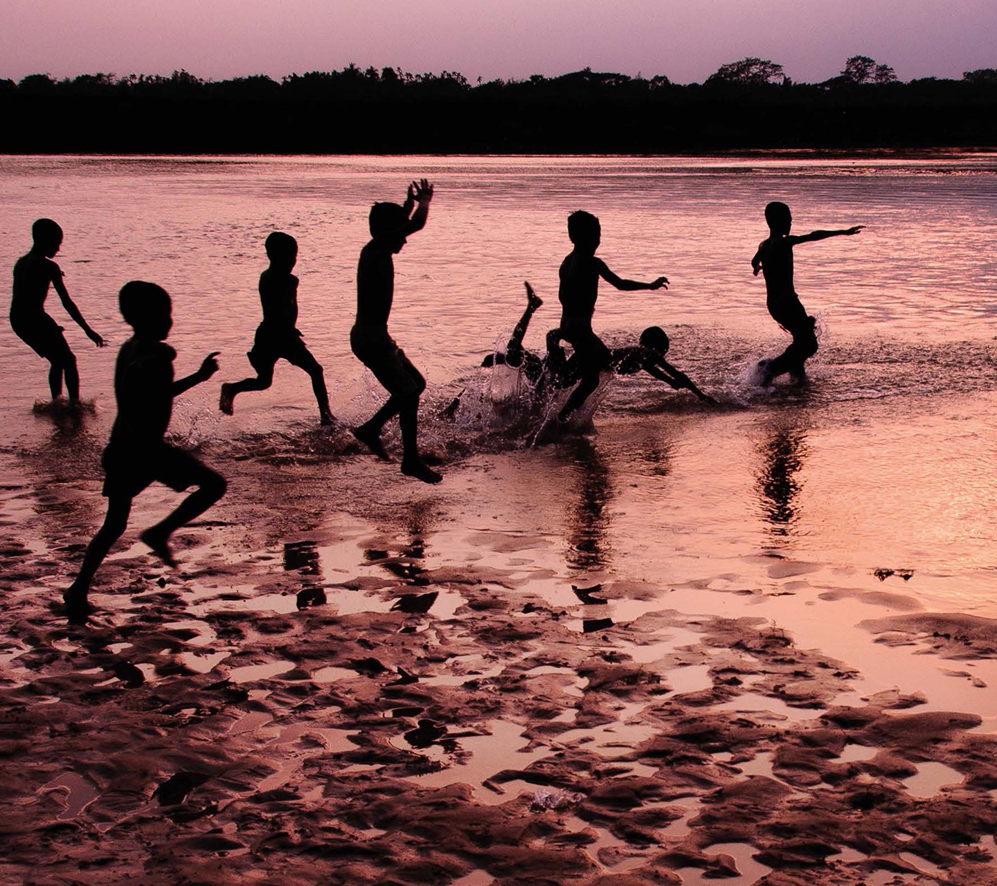 Kids splashing in water and playing by the shore